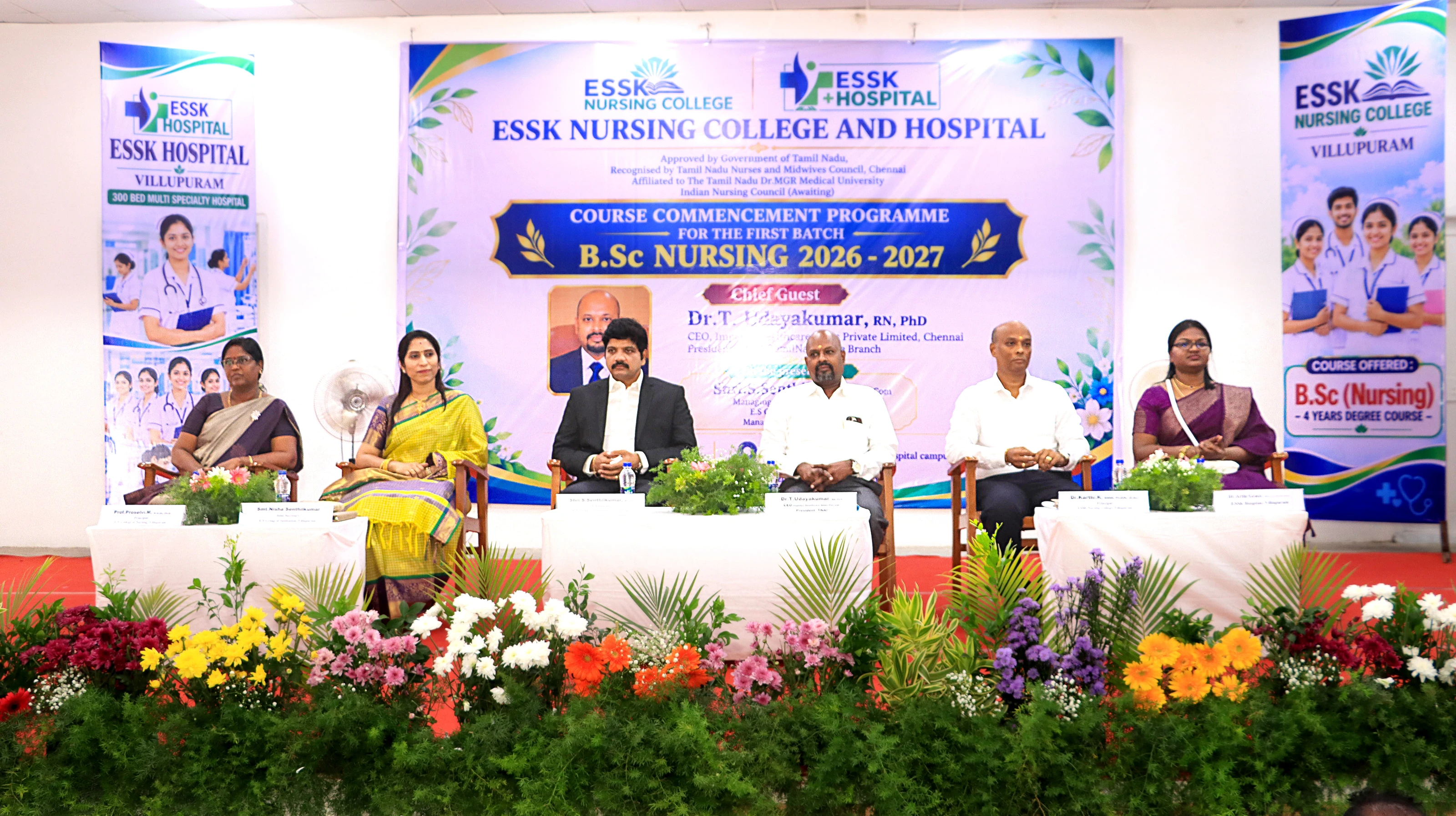 Guests and college staff seated on a stage under a banner for the B.Sc Nursing 2026–2027 course commencement programme