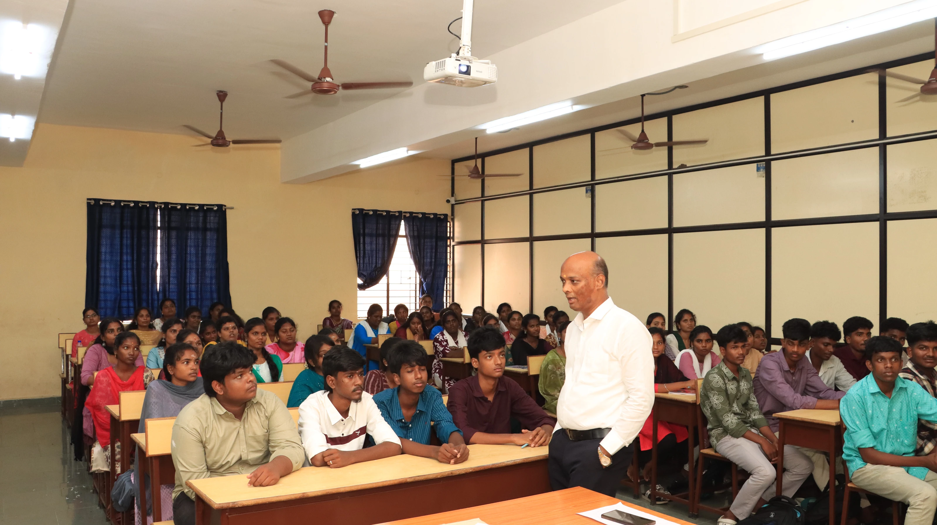 First-year B.Sc Nursing students at their desks in a classroom, listening to a speaker
